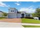 Well-maintained two-story house with a three-car garage, brick paved driveway, and lush green lawn at 1265 Blarney St, Minneola, FL 34715