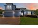 Charming two-story home featuring a three-car garage, brick driveway, manicured lawn, and arched entryway at 1265 Blarney St, Minneola, FL 34715