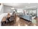 Open-concept living and dining area with hardwood floors, modern furnishings, and a view of the kitchen at 1265 Blarney St, Minneola, FL 34715