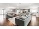 Spacious living area with wood floors, plush seating, and a partial view of the kitchen and dining room at 1265 Blarney St, Minneola, FL 34715