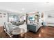 Bright living room with wood floors, modern sofas, accent chairs, a media center, and sliding glass doors at 1265 Blarney St, Minneola, FL 34715