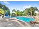 Spacious community pool with umbrella seating, palm trees, and tropical plants at 1325 Lake Shadow Cir # 12303, Maitland, FL 32751