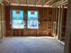 Framing of a bedroom in new construction showing dual windows and visible outdoor landscape at 15465 Hamlin Park Drive, Winter Garden, FL 34787
