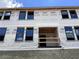 Townhome construction featuring multiple windows and sturdy block foundation, covered in Ashton Woods branded wrap at 15465 Hamlin Park Drive, Winter Garden, FL 34787