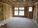 The living room of a new home under construction, featuring multiple windows that let in natural light and a spacious open floor plan at 15465 Hamlin Park Drive, Winter Garden, FL 34787