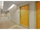 Condominium hallway with neutral walls and a vibrant yellow unit door at 155 S Court Ave # 1909, Orlando, FL 32801
