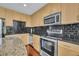 Close-up of kitchen with stainless steel appliances, modern backsplash and countertops and wood cabinets at 155 S Court Ave # 1909, Orlando, FL 32801