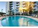 Community pool with lounge chairs with high rise in the background at 155 S Court Ave # 1909, Orlando, FL 32801