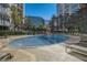 Community pool with surrounding lounge chairs and lush landscaping at 155 S Court Ave # 1909, Orlando, FL 32801
