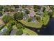 An aerial view showcases the property's location within a lush neighborhood, backing onto a serene pond at 1748 Harvest Cv, Winter Park, FL 32792