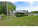 Another angle of backyard with lush greenery and mature palm trees at 1748 Harvest Cv, Winter Park, FL 32792