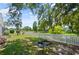 Lush backyard with a fire pit, bordered by a classic white picket fence at 1748 Harvest Cv, Winter Park, FL 32792