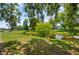 Picturesque backyard view featuring lush green grass and mature trees along a tranquil stream at 1748 Harvest Cv, Winter Park, FL 32792