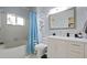Cozy bathroom with shower-tub combo, storage shelves, vanity, and mirror at 1748 Harvest Cv, Winter Park, FL 32792