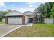 Charming single-story home featuring a brick facade, white siding, and a two-car garage in a residential neighborhood at 1748 Harvest Cv, Winter Park, FL 32792
