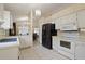 Functional kitchen featuring white appliances and cabinets, with easy access to dining area at 1748 Harvest Cv, Winter Park, FL 32792