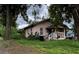 Charming single-story home with a covered porch and white trim, surrounded by lush greenery and trees at 1996 Indiana Ave, Winter Park, FL 32789