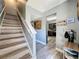 Welcoming entryway with a staircase and view into the modern kitchen at 200 Saint Andrews Blvd # 3002, Winter Park, FL 32792