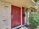 Close-up of the red front door featuring a modern smart lock and matching mailbox at 200 Saint Andrews Blvd # 3002, Winter Park, FL 32792