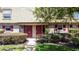 This exterior shot features a well-manicured lawn, bushes and the red front doors at 200 Saint Andrews Blvd # 3002, Winter Park, FL 32792