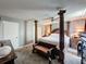 This bedroom features a four-poster bed, a sitting bench, carpet floors and neutral paint at 200 Saint Andrews Blvd # 3002, Winter Park, FL 32792
