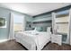 Bedroom with blue accent wall, striped wall trim, and white bedding at 2927 Fable St, Kissimmee, FL 34746