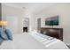 Bright bedroom with a white bed, wooden dresser, and a TV on the wall at 2927 Fable St, Kissimmee, FL 34746