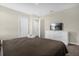 Neutral bedroom featuring a large bed, white dresser with TV, and two closets at 2927 Fable St, Kissimmee, FL 34746