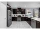 Kitchen featuring stainless steel appliances, dark wood cabinets, white countertops, and elegant marble-style flooring at 2927 Fable St, Kissimmee, FL 34746