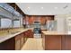 Well-equipped kitchen featuring stainless steel appliances, granite countertops, mosaic backsplash, and custom wood cabinetry at 3217 Castle Oak Ave, Orlando, FL 32808