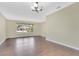 Open living area features dark hardwood flooring, neutral walls, and a large window offering natural light at 3217 Castle Oak Ave, Orlando, FL 32808