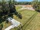 Aerial view of the fenced community dog park with green space, a seating area, and a water station at 3334 Arch Ave, Ormond Beach, FL 32174