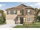 Charming two-story home boasting stone accents, a covered entryway, and a convenient two-car garage at 3334 Arch Ave, Ormond Beach, FL 32174