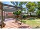 Spacious wooden deck has a pergola that is surrounded by a well-manicured lawn and mature trees at 338 E Anderson St, Orlando, FL 32801
