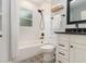 This bathroom features a shower/tub combo, subway tile, a decorative floor, a white vanity, and black fixtures at 338 E Anderson St, Orlando, FL 32801
