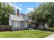 Well-maintained gray two-story home with a brick chimney, lush lawn, and beautiful landscaping at 338 E Anderson St, Orlando, FL 32801