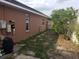 Exterior side yard featuring partial hardscape and grass with home's electric system on the exterior wall at 340 Haversham Way, Davenport, FL 33897