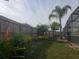 Backyard featuring a privacy fence, tropical plants, and a screened enclosure at 340 Haversham Way, Davenport, FL 33897