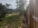 Spacious backyard featuring a lush lawn, mature tree, and wooden fence for added privacy at 340 Haversham Way, Davenport, FL 33897
