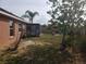 Large backyard with screen enclosure, palm tree, and a wood fence surrounding the property at 340 Haversham Way, Davenport, FL 33897