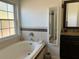 Spacious bathroom with a large tub, window, and tiled walls at 340 Haversham Way, Davenport, FL 33897