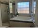 Bathroom featuring a large tub with a separate glass shower, and tiled surround at 340 Haversham Way, Davenport, FL 33897