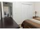 Bedroom view showcasing closet doors, modern flooring, and a comfortable bed, with a glimpse into the hallway at 340 Haversham Way, Davenport, FL 33897