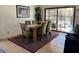 Inviting dining room with rustic wooden table, plush chairs, and sliding glass doors to the outdoor pool area at 340 Haversham Way, Davenport, FL 33897