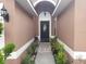 Inviting front entrance with a decorative door, covered porch, and well-maintained landscaping at 340 Haversham Way, Davenport, FL 33897
