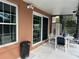 View of a covered patio with table, chairs, and sliding doors leading inside at 340 Haversham Way, Davenport, FL 33897