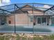 Back of house view from the screened in pool, showing patio and exterior wall at 340 Haversham Way, Davenport, FL 33897