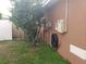 Exterior side yard featuring grass with the home's electric system on the exterior wall at 340 Haversham Way, Davenport, FL 33897