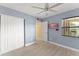Bright bedroom with a ceiling fan, a closet, and a window allowing natural light at 3475 Flossmoor Ave # 103, Orlando, FL 32822