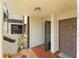 View of the entryway featuring a brown-tiled floor, brown door, and a black screen door at 3475 Flossmoor Ave # 103, Orlando, FL 32822